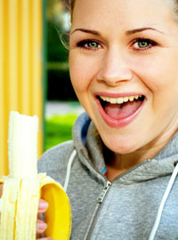 Девушка ест банан