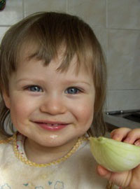 Девочка ест лук